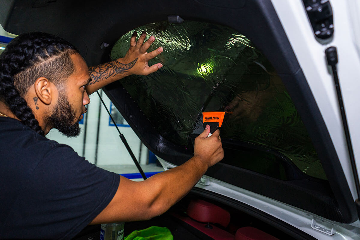 Polar Tint Henderson installer applying Premium Ceramic Nano Ceramic window tint film to a vehicle side window
